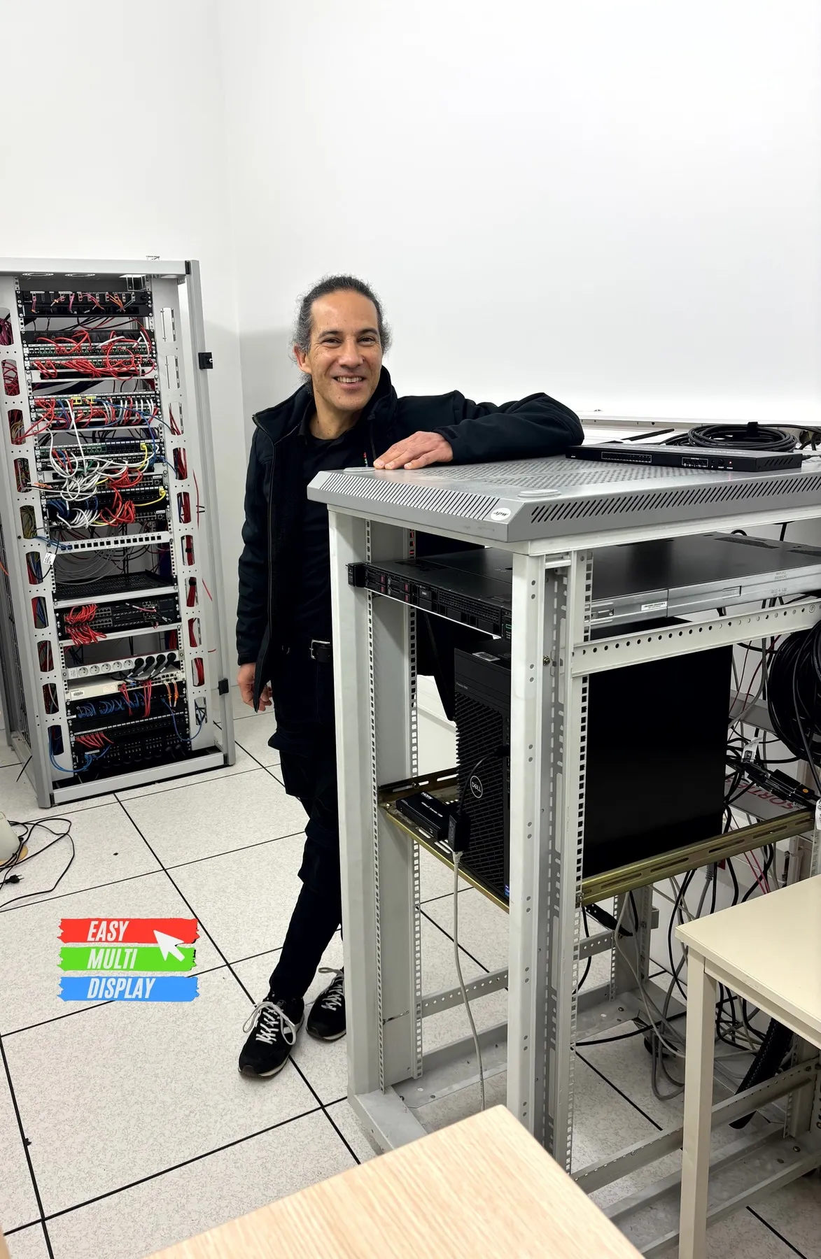 Patrice Barrault, founder of Easy Multi Display, in front of an equipment rack